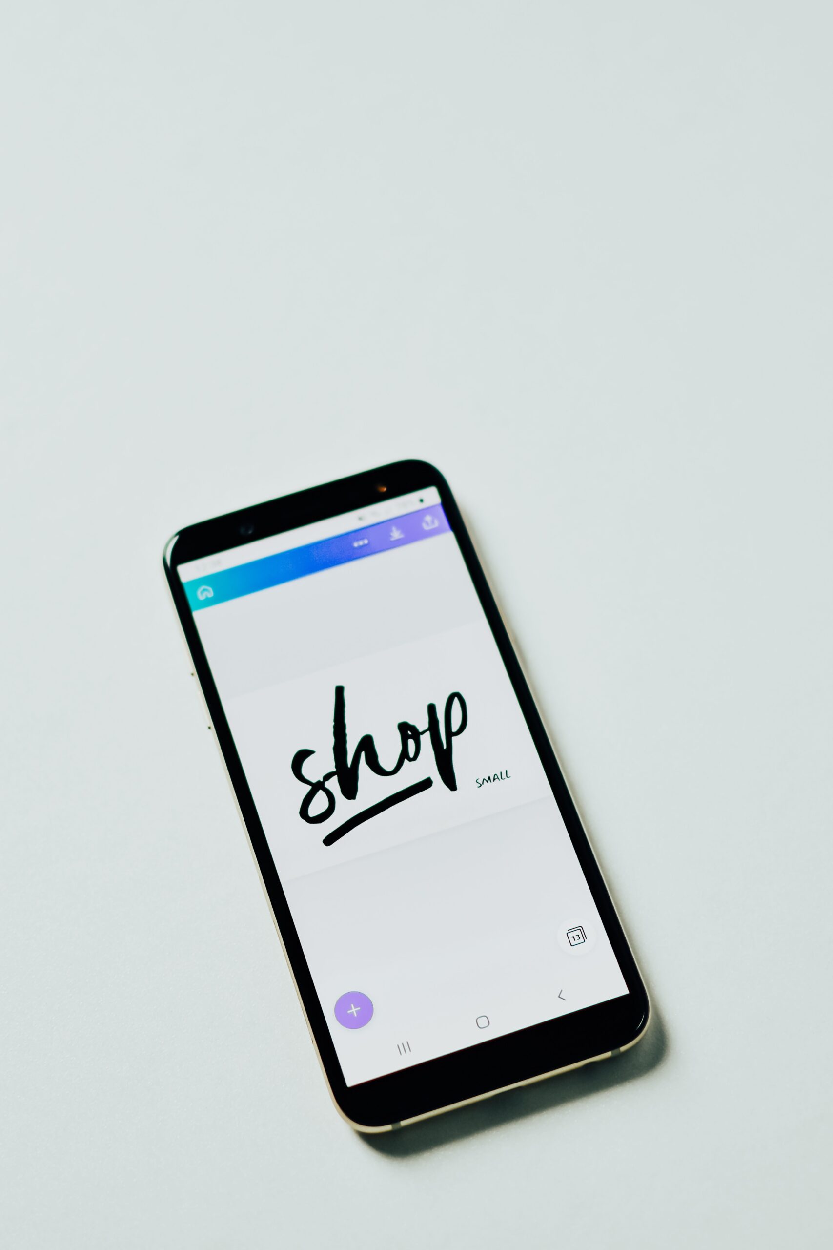 A close-up shot of a smartphone with a shopping app on a white surface, ideal for e-commerce themes.