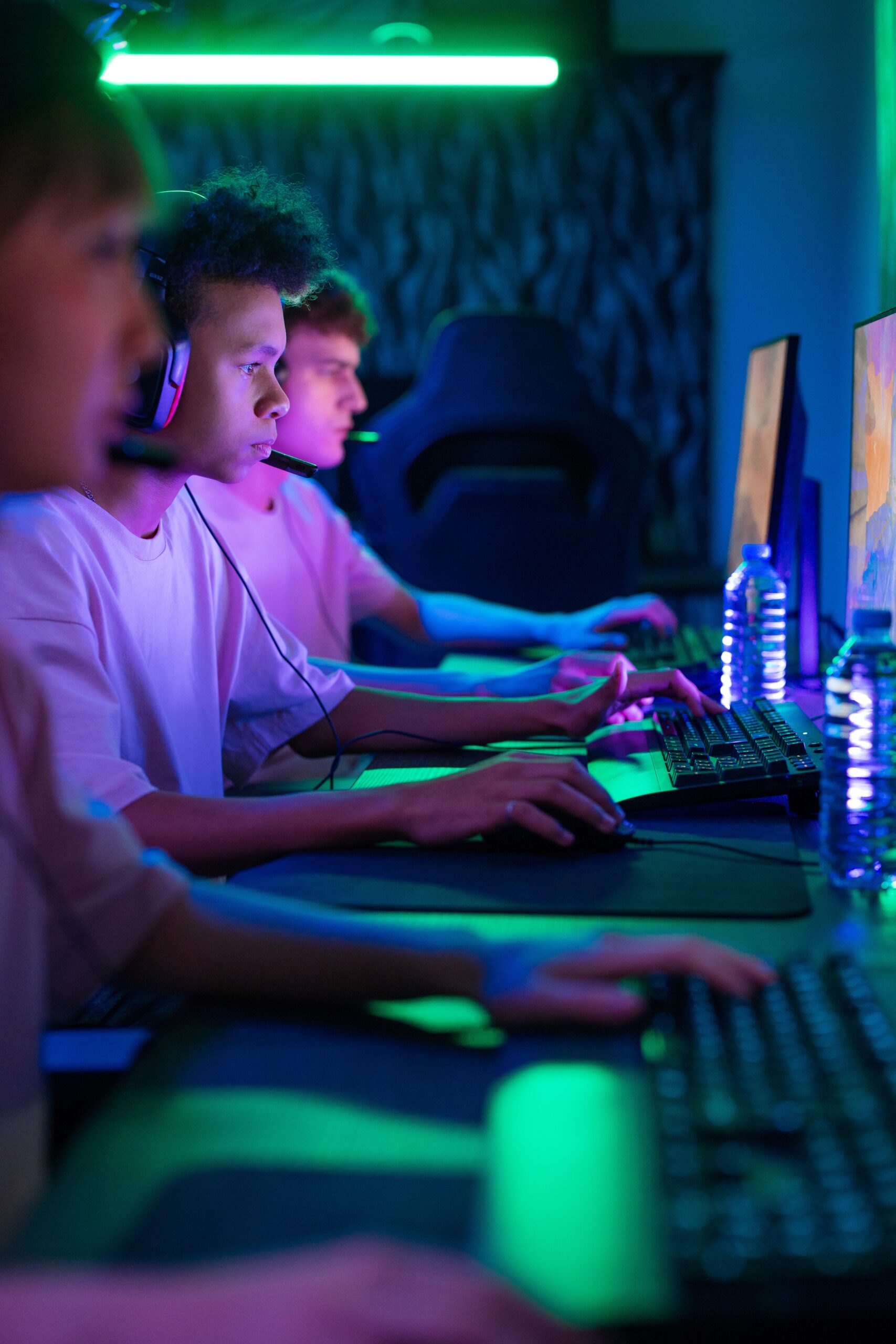 A group of young adults intensely focused on a gaming competition in a vibrant setting.